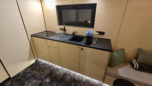 a small room with a sink and a tv on the wall at RE Plai in Zărneşti