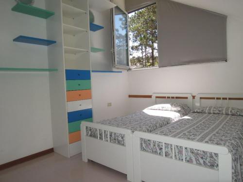 a bedroom with two beds and a window at Spacious apartment with terrace and pool in Bibione in Bibione