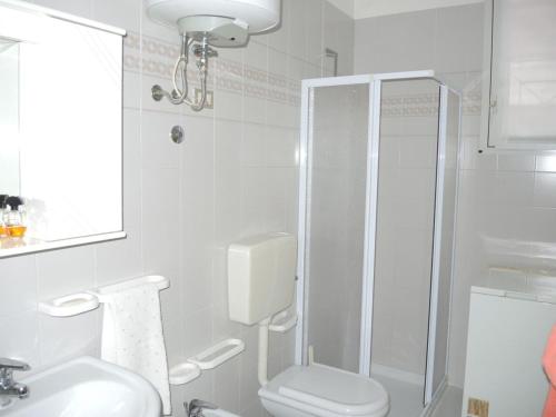 a bathroom with a shower and a toilet and a sink at Spacious apartment with terrace and pool in Bibione in Bibione
