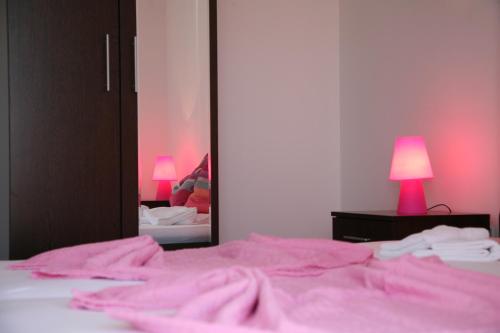 a bedroom with a pink bed and a mirror at Vila in Lavanda in Fažana
