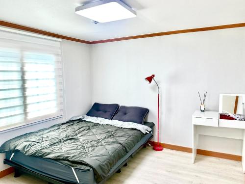 a bedroom with a bed and a lamp at 포항 Jin house in Pohang