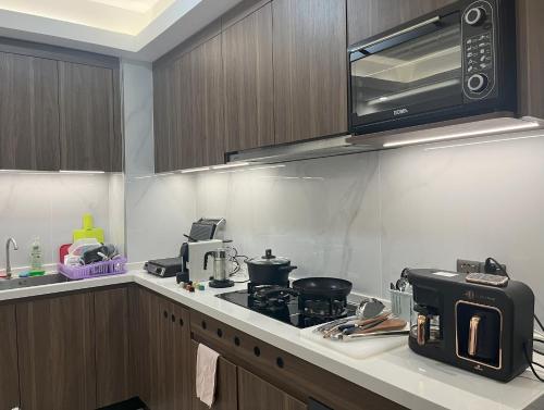 a kitchen with a stove and a microwave at Affordable Luxury Rooms with Pool, Gym and Office Space in Kigali