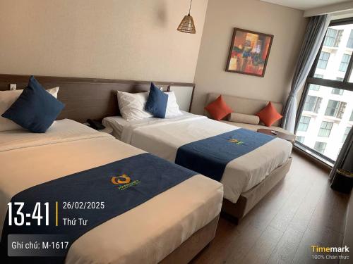 a hotel room with two beds and a window at APEC MANDANA CHAM BAY Mũi Né in Ấp Thiẹn Ái