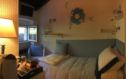 a bedroom with a bed and a chair and a lamp at B&B Le Tre Casette in Maratea