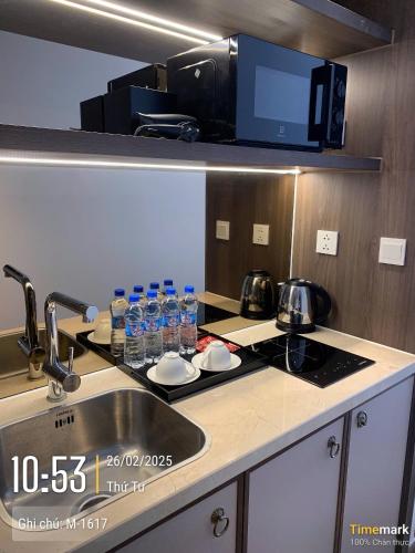 a kitchen with a sink and a counter with water bottles at APEC MANDANA CHAM BAY Mũi Né in Ấp Thiẹn Ái