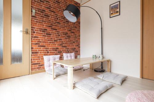 a table and chairs in a room with a brick wall at Minowa Sta Direct to Ueno in Tokyo