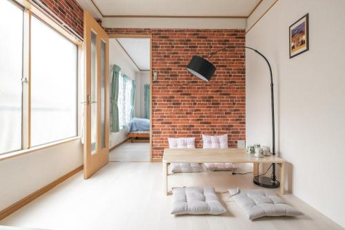 Habitación con mesa y pared de ladrillo en Minowa Sta Direct to Ueno, en Tokio