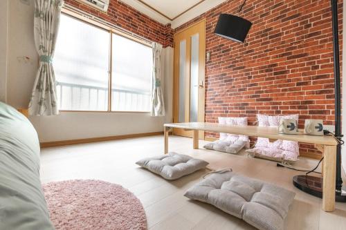 a bedroom with a brick wall and a table at Minowa Sta Direct to Ueno in Tokyo