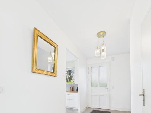 un couloir avec des murs blancs et un miroir sur le mur dans l'établissement -OZARIO- Magnifique maison au Cabellou, à Concarneau