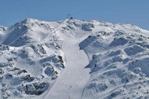 a mountain covered in snow with a ski trail at Bohinj River House in Bohinj