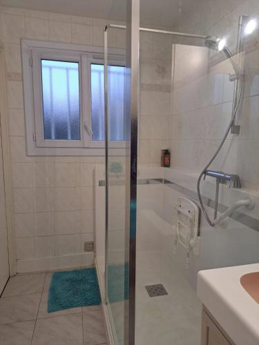une salle de bain avec une douche avec une porte vitrée dans l'établissement Les Portes de l'Océan, à Vaux-sur-Mer