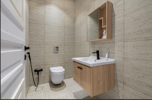 a bathroom with a toilet and a sink and a mirror at شقة بتصميم انيق مقابل الافنيوز d11 in Riyadh