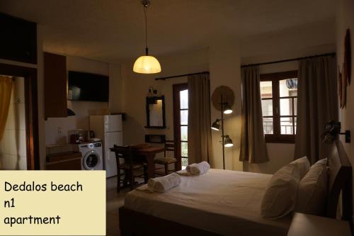 a bedroom with a bed and a kitchen with a table at Dedalos Beach n1 ground floor in Stalida