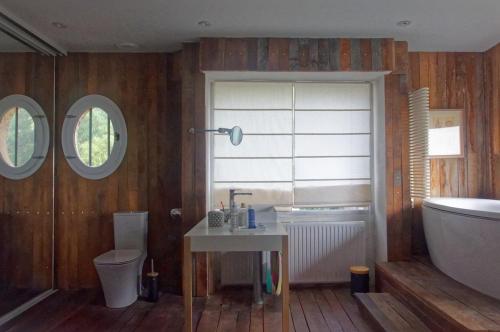 a bathroom with a tub and a toilet and a sink at Maison de campagne Proche de St Emilion in Montcaret