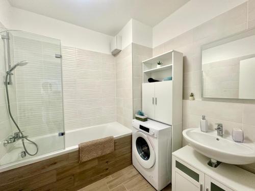 a white bathroom with a washing machine and a sink at BudaBright 192 II FreeParking in Budapest
