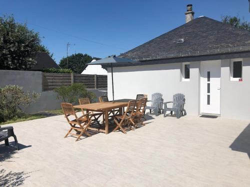 une table et des chaises en bois sur une terrasse dans l'établissement La Louisine séjours du samedi au samedi, à Séné