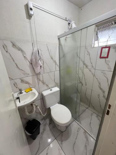 a bathroom with a toilet and a sink at Casa MR Brutomesso 2 in Londrina