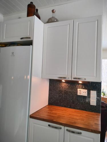 a kitchen with white cabinets and a wooden counter top at 3 room apartment&terrace in Espoo