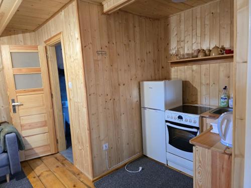 a small kitchen with a refrigerator and a stove at ROZTOCZE u ALEKSA SUSIEC - JACUZII , GORĄCA BALIA!!! in Susiec