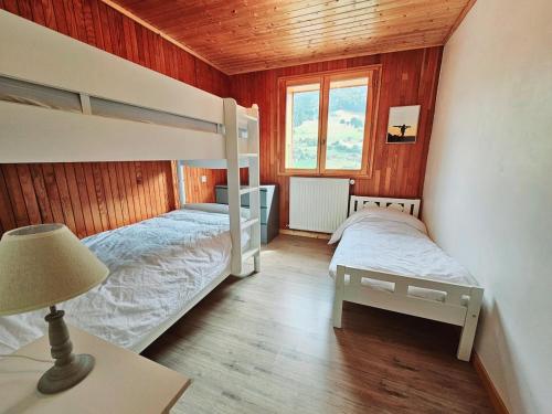 una camera con 2 letti a castello e una lampada di Chalet Sterenn, 10 personnes, Grand Bornand et La Clusaz a Entremont