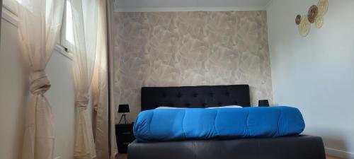 a blue bed in a bedroom with a wall at Hotel airport in Merville