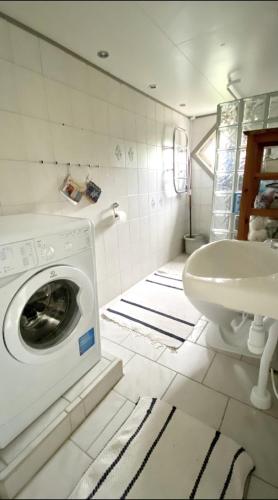 a bathroom with a washing machine and a sink at Charming Bohuslän Cottage with Nature Views in Lysekil