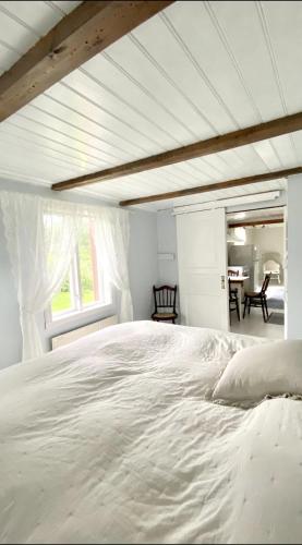 a bedroom with a large white bed and a table at Charming Bohuslän Cottage with Nature Views in Lysekil