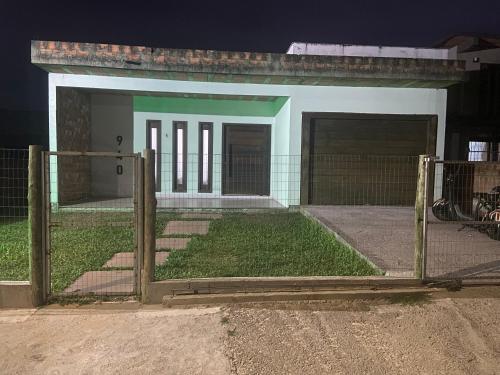 a gate in front of a house with a yard at Casa na praia em Torres my house in Torres in Torres