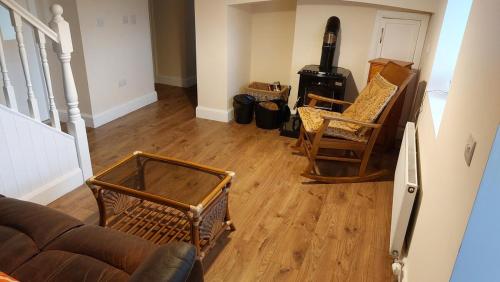 a living room with a couch and chairs and a stove at Mount Leinster Cottage in Bagenalstown