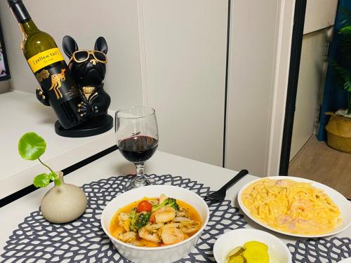a table with two bowls of pasta and a glass of wine at Near Incheon airport, China town, Songdo, Inha Uni Hospital in Incheon