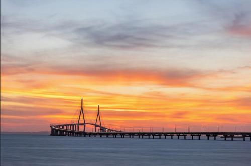 a bridge over the water with a sunset in the background at Near Incheon airport, China town, Songdo, Inha Uni Hospital in Incheon