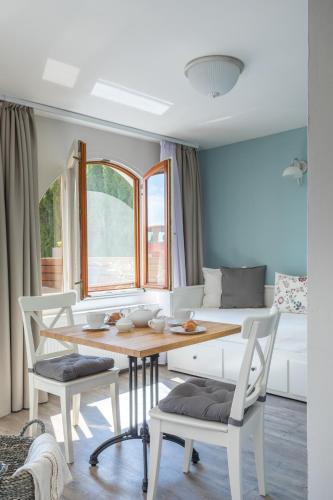 a dining room with a table and chairs and a couch at Kapri Vendégház in Badacsonytomaj