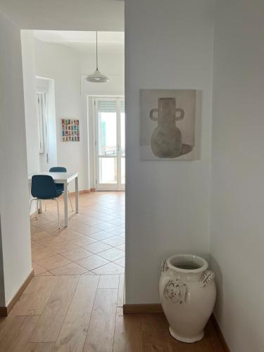 una habitación con una mesa y un jarrón en el suelo en Civico 18, en Bernalda