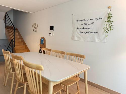 une salle à manger avec une table et des chaises blanches dans l'établissement Everland Station 5 minutes on foot, Gamsung Accommodation Everland, Caribbean Bay, Korean Folk Village, Yongin Sevens, Stay Jal Jal, à Yongin