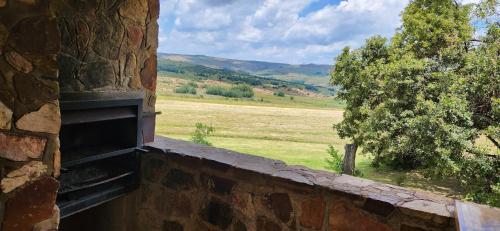 a brick wall with a view of a field at Field and Stream in Dullstroom