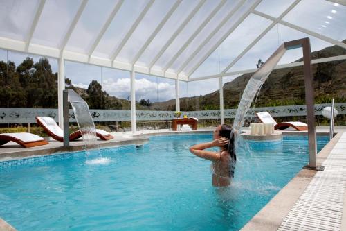 a woman in a swimming pool under a tent at Aranwa Pueblito Encantado del Colca in Coporaque