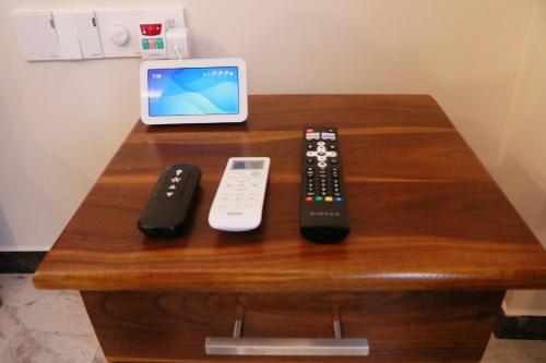 a table with three remote controls and an ipod at Sunset Cove Ahangama in Ahangama