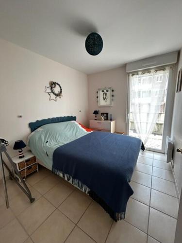 - une chambre avec un lit doté d'une couverture bleue dans l'établissement Astéries - RDC, à Quend-Plage