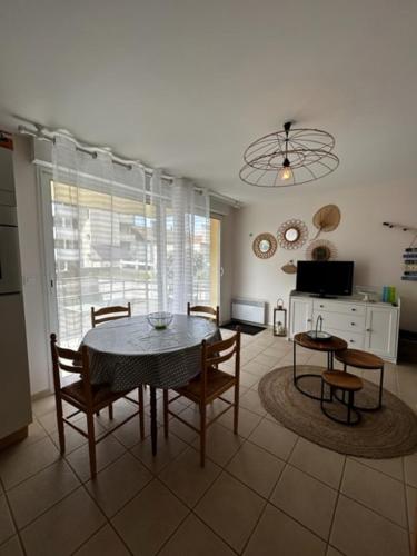 un salon avec une table et des chaises de salle à manger dans l'établissement Astéries - RDC, à Quend-Plage