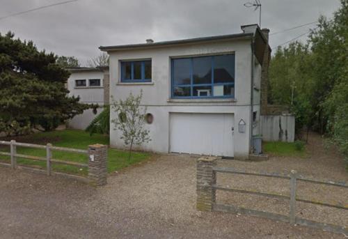 une maison blanche avec une clôture devant dans l'établissement Le Radeau Maison 50m de la Mer - 6P - 3 Chambres 2 SDB, à Ver-sur-Mer