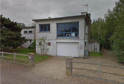 une maison blanche avec une grande fenêtre et une clôture dans l'établissement Le Radeau Maison 50m de la Mer - 6P - 3 Chambres 2 SDB, à Ver-sur-Mer