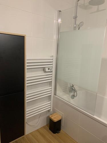 La salle de bains blanche est pourvue d'une douche et d'une baignoire. dans l'établissement Charmante maison au calme proche de Paris, à Achères