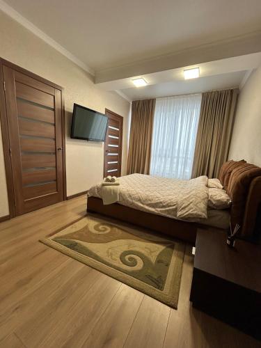 una camera da letto con un letto e una TV a schermo piatto di Gold a Chişinău