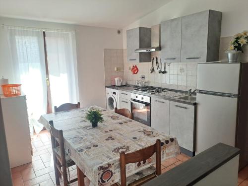 une cuisine avec une table et un réfrigérateur blanc dans l'établissement Casa Rachele, à Rome
