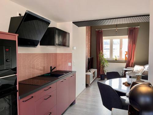 - une cuisine avec un évier et une table dans une chambre dans l'établissement LE DRAGON - gîte accueillant, à Malmedy