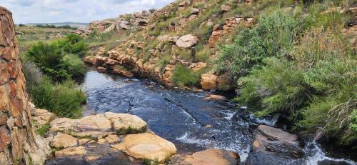 a stream of water in a canyon with rocks at Field and Stream in Dullstroom
