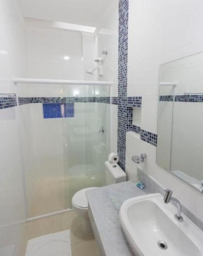 a bathroom with a sink and a shower and a toilet at Hotel Camburi Praia in Camburi