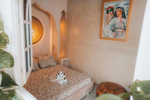a room with a bed and a picture on the wall at PALACIO AL ANDALUS in Chefchaouene
