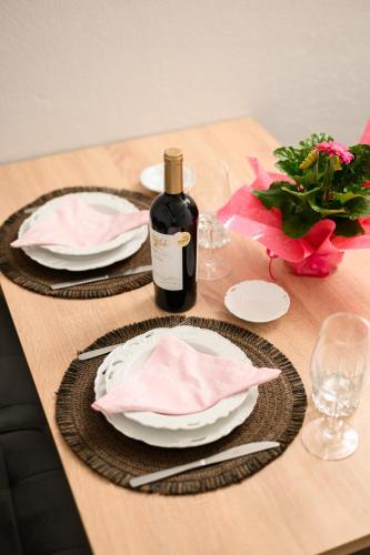a wooden table with plates and a bottle of wine at LakeSide Apartment in Kastoria