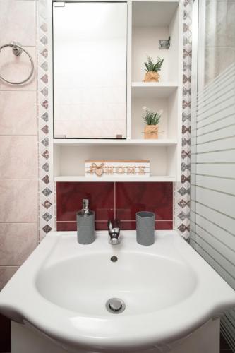 a bathroom with a white sink and a mirror at LakeSide Apartment in Kastoria